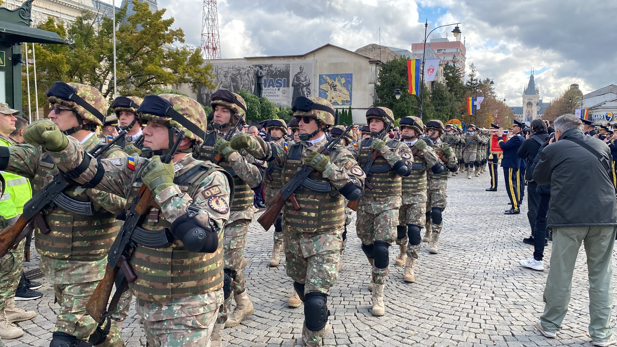 Coloană de militari în defilare pe pietonalul din Iași, cu fanfara militară în plan secund
